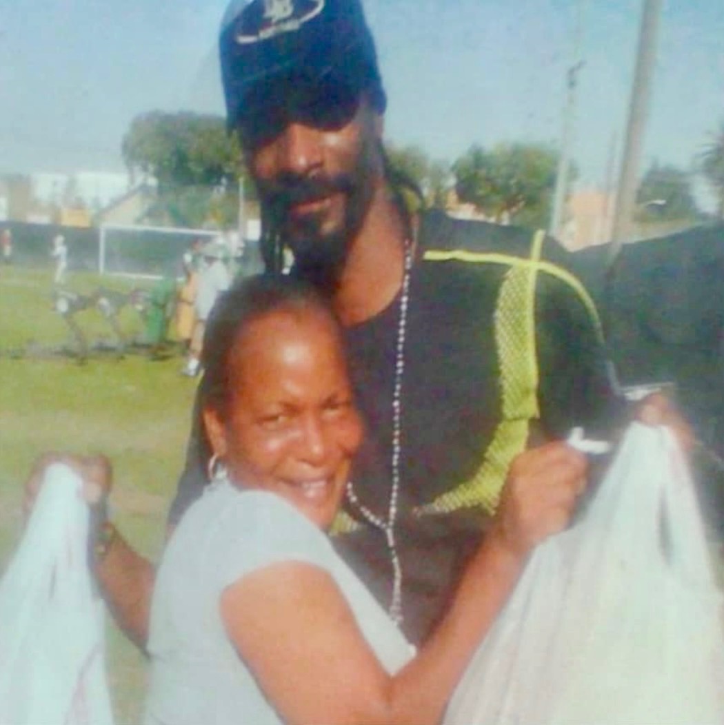 Darlene Young embracing Snoop Dogg at a community event